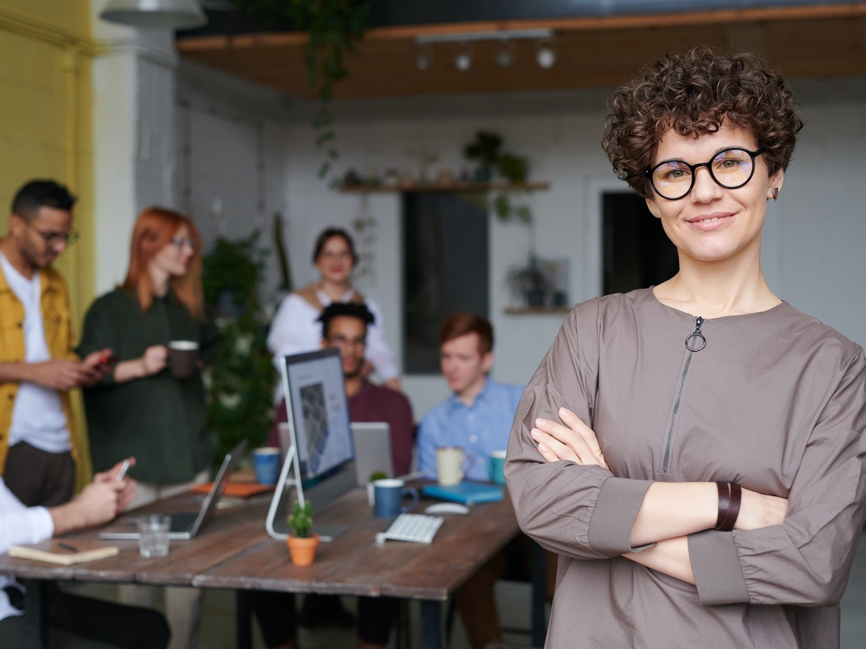 lady with glasses, arms folded, and smiling